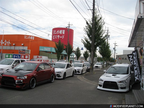Rare car photo of several JDM 2008 Mitsubishi Evo X vehicles parked in front 