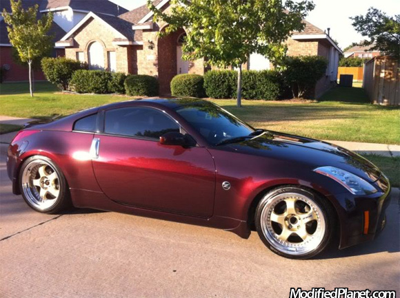  red 2003 Nissan 350Z sitting on a set of gold 19 Work Meister wheels